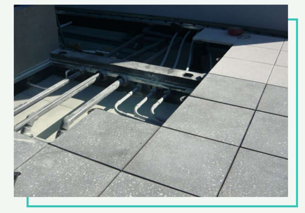 Pedestal paver system with exposed electrical and plumbing routed cleanly underneath deck surface